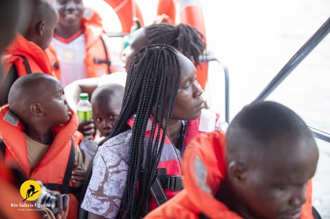Group of people wearing orange life vests on what appears to be a rescue or maritime vessel