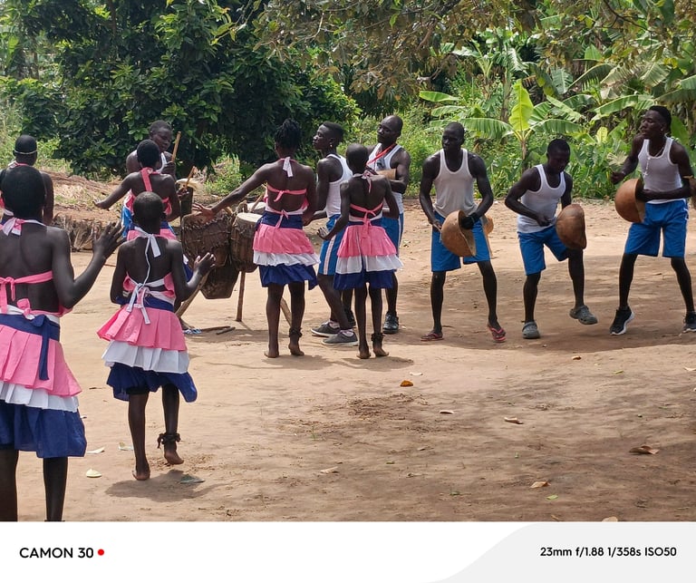 Group of children playing and dancing together on a dirt road with lush green vegetation in the background