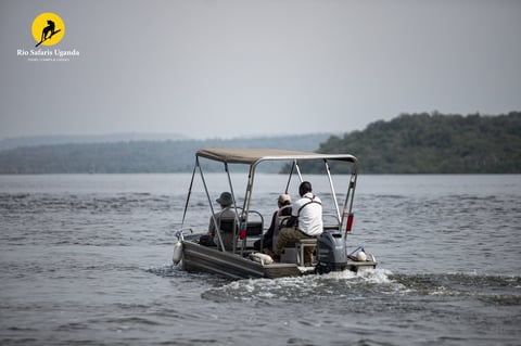 Small motorboat with canopy carrying three people on a lake with forested shoreline in background